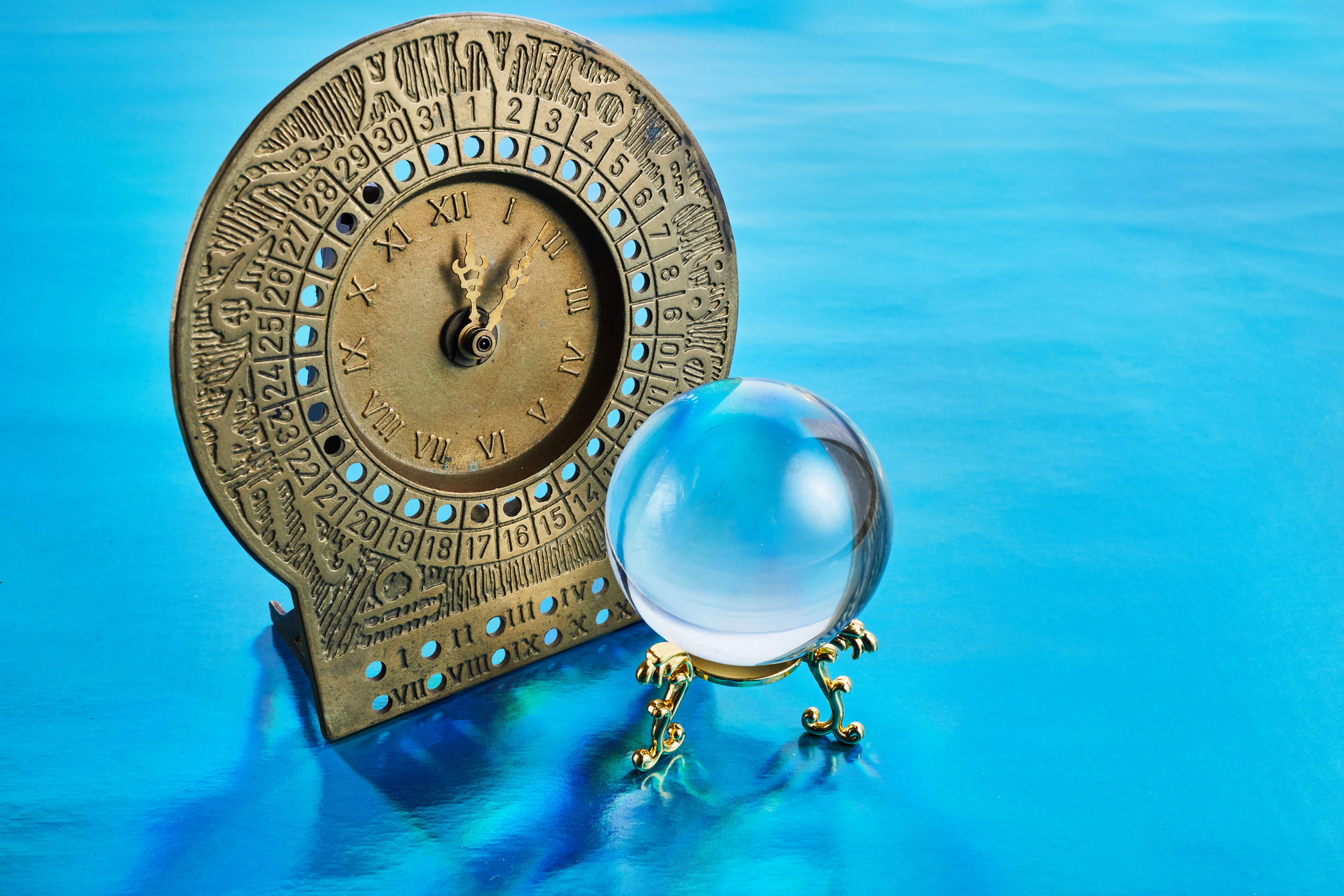 Antique Clock and Crystal Ball on a Blue Background 